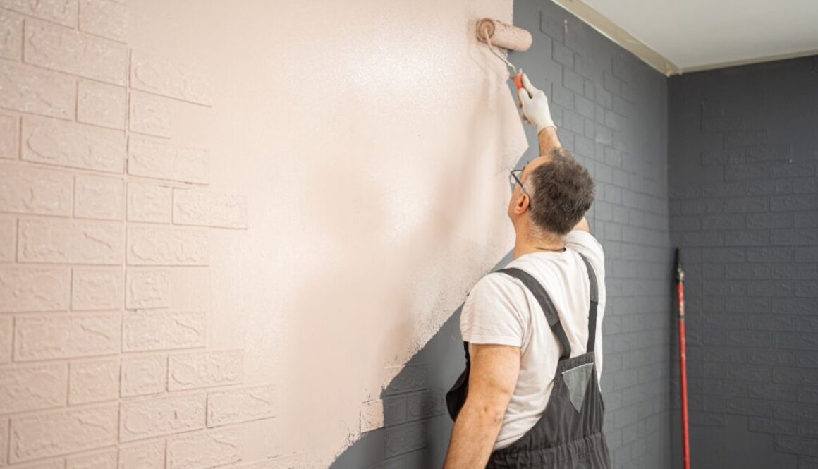 Man,Painting,Brick,Wall,With,Paint,Roller